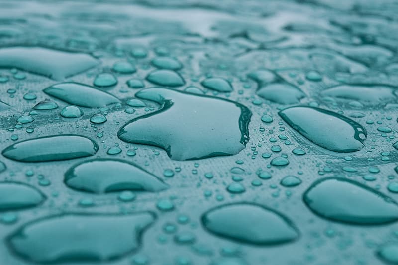 Water droplets crowd on a blue surface.