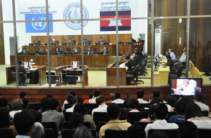 The Khmer Rouge tribunal. The tribunal proper is behind a large, curved window, behind which a crowd watches the proceedings.