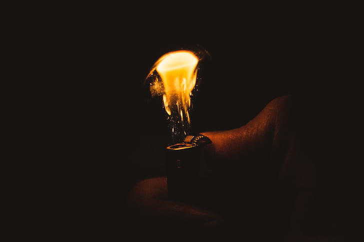 A photograph of a hand flicking a lighter on.