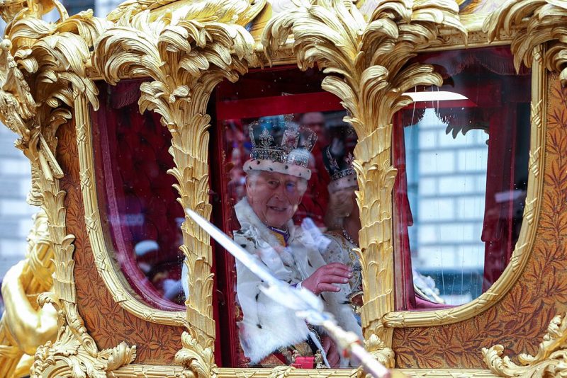Charles III and his wife Camilla, photographed during the coronation procession in an ornate gold carriage.
