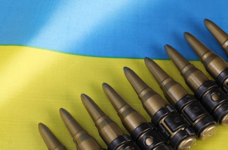 A ribbon of bullets on top of the Ukrainian flag.