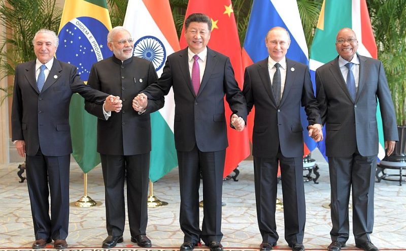 B.R.I.C.S. leaders (from left: Michel Temer, Brazil; Narendra Modi, India; Xi Jinping, China; Vladimir Putin, Russia; Jacob Zuma, South Africa), photographed holding hands with each man next to him. Xi, center, is noticeably taller than the others.